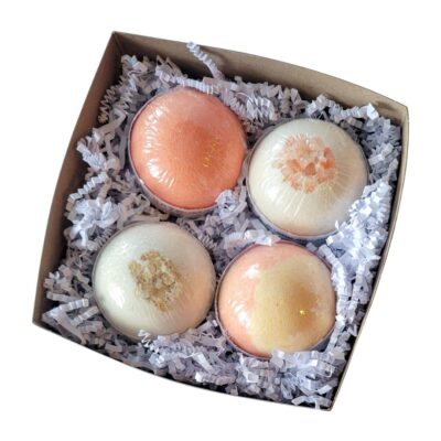 A gift box containing 4 bath bombs: Satsuma, Mango Sunrise, Island Coconut, and Oats and Honey.